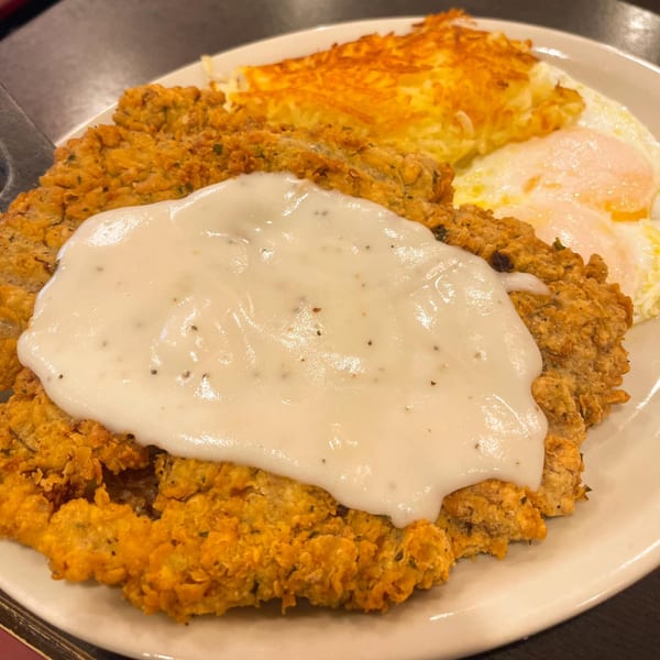 Good Day Cafe's chicken fried steak with gravy, hash browns, and two fried eggs.