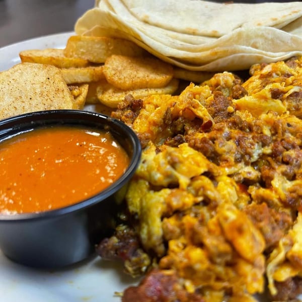 A Good Day Cafe breakfast plate with scrambled eggs, chorizo, tortillas, home fries, and salsa.
